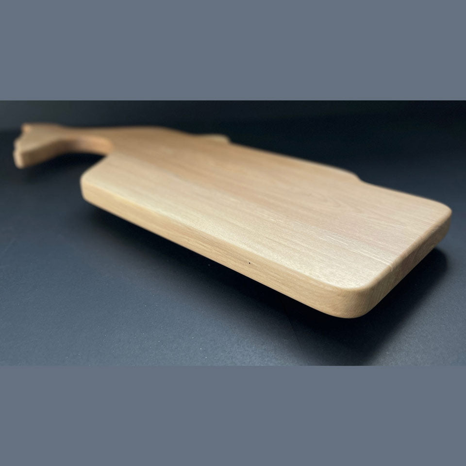 Profile of handcrafted whale board highlighting curved body and tail