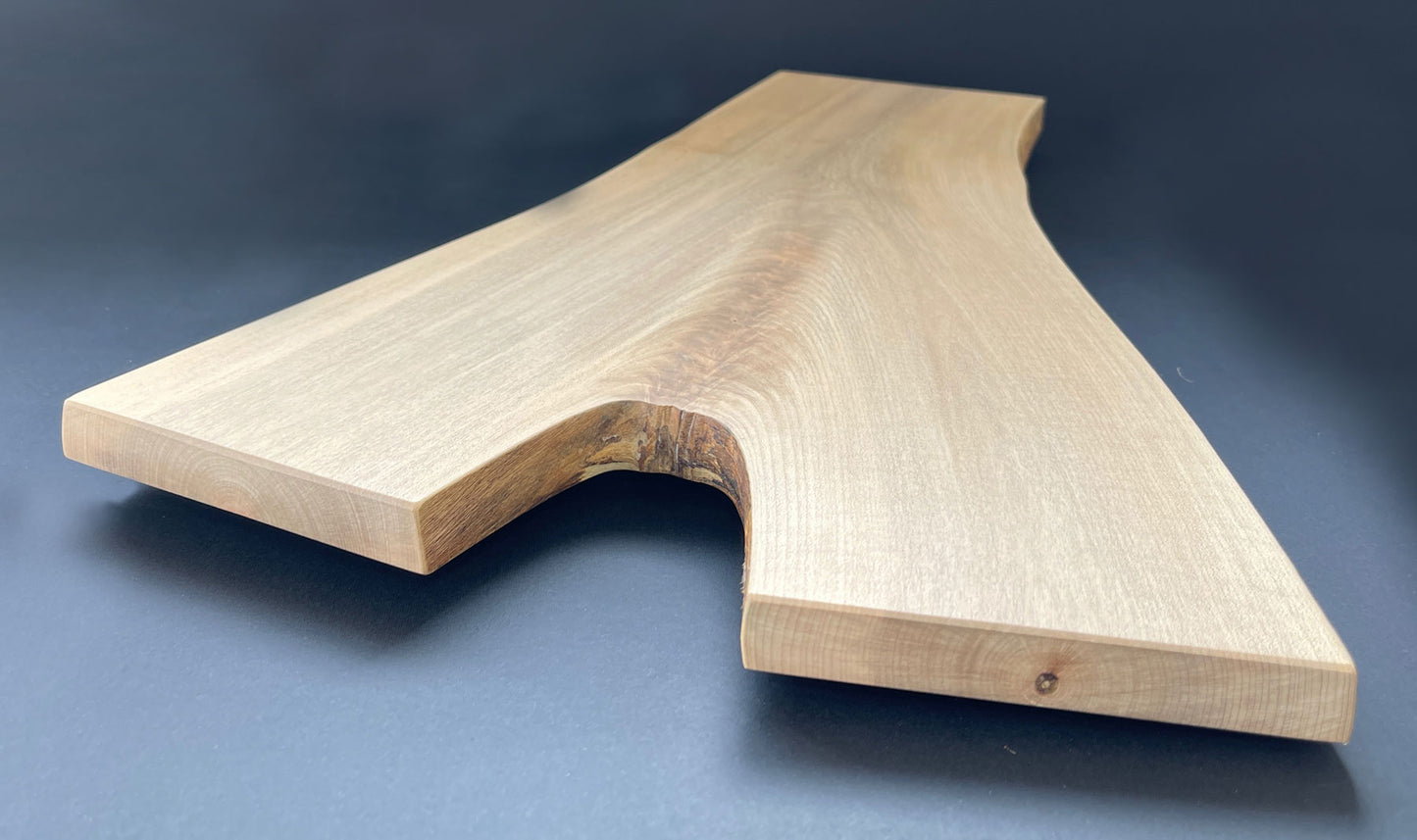 Natural live edge of Y-shaped maple board highlighting wood texture