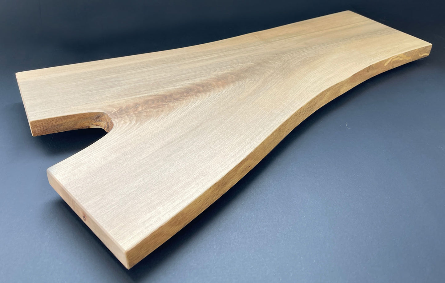 Natural live edge of Y-shaped maple board highlighting wood texture