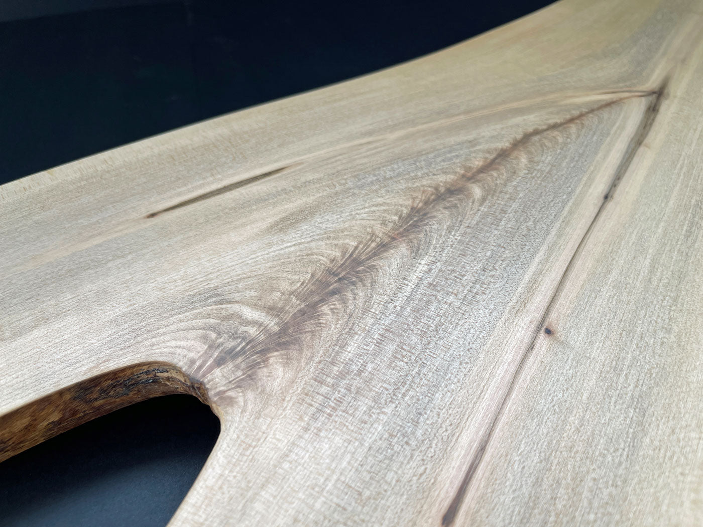 Natural live edge of Y-shaped maple board highlighting wood texture