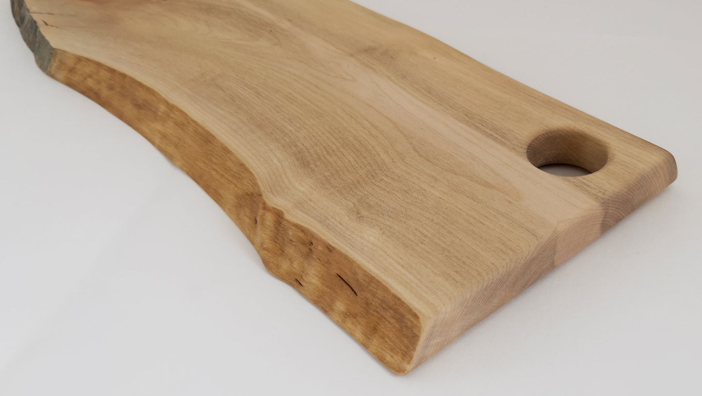 Detail of O-shaped cutout on maple charcuterie board