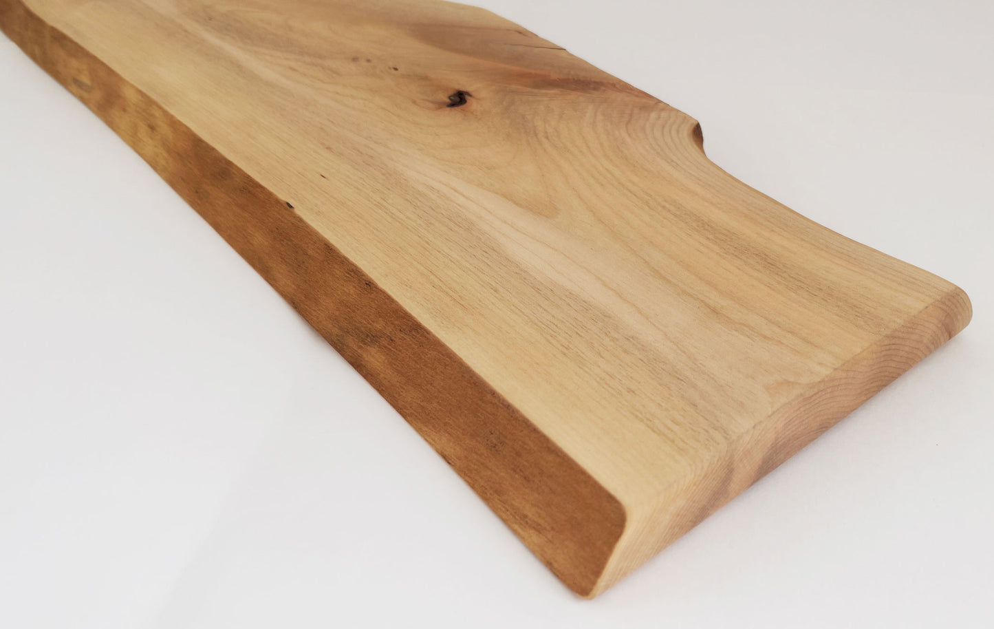 Live edge maple serving board with natural wood grain and circular handle