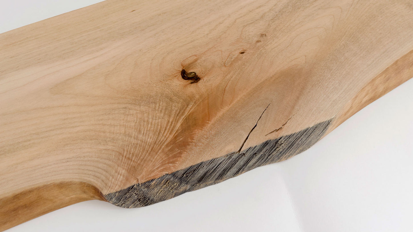 Live edge maple serving board with natural wood grain and circular handle