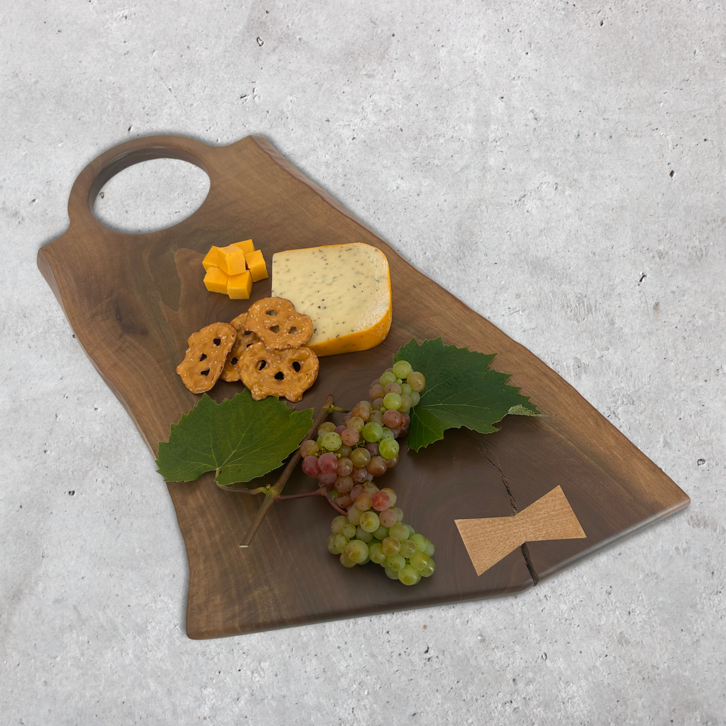 Black walnut Big O handle board used for charcuterie with meats, cheese, and fruit