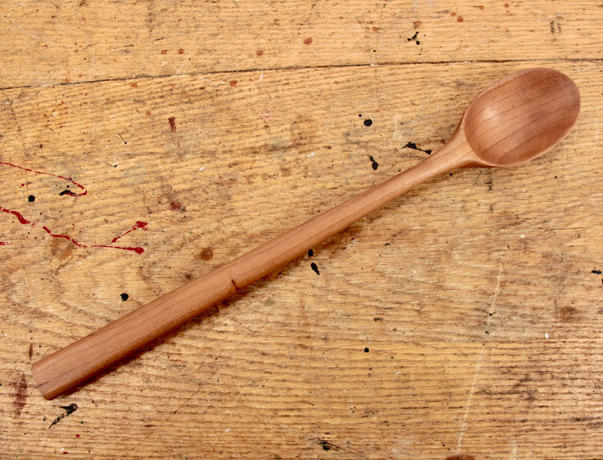 Close-up of polished cherry wood grain on handcrafted spoon