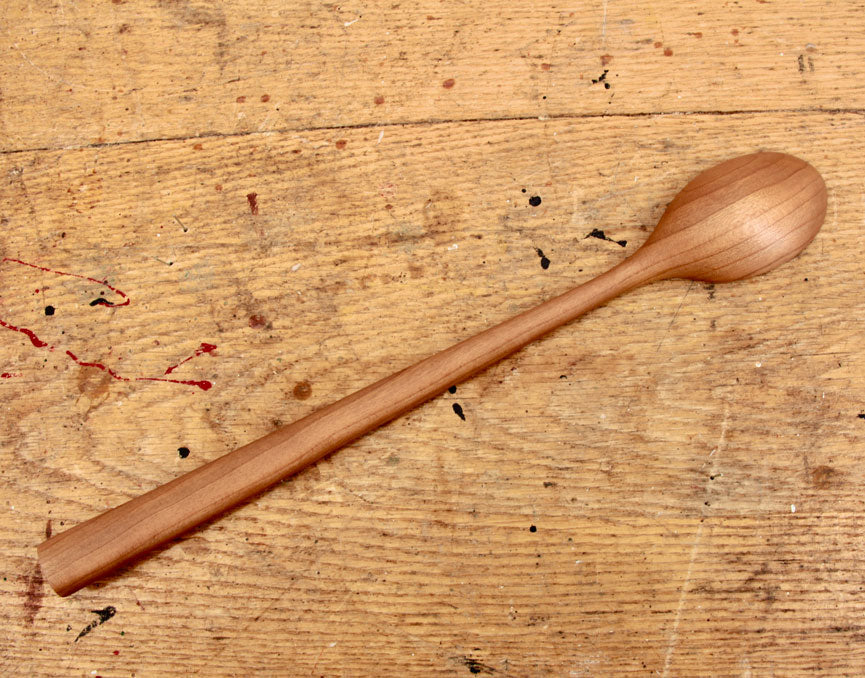 Close-up of polished cherry wood grain on handcrafted spoon
