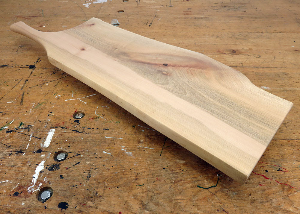Live edge maple charcuterie board with rustic grain and ergonomic handle