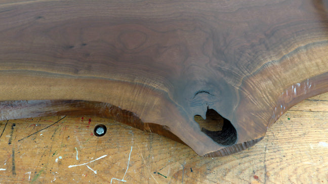 Close-up of black walnut wood grain and live edge detail on charcuterie board
