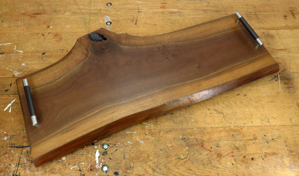 Top-down view of handcrafted black walnut charcuterie board with natural edge