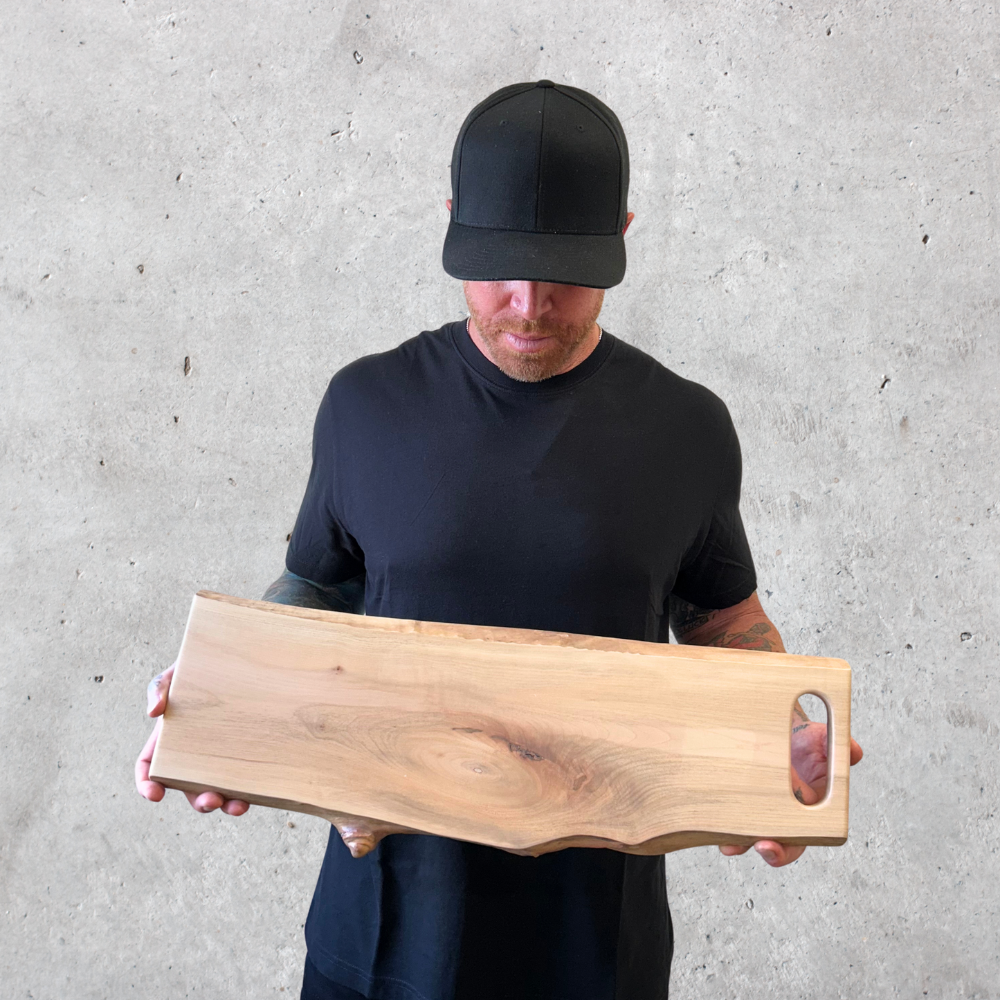 Live edge maple charcuterie board with integrated slot handle and rich wood grain